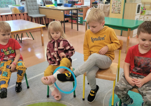 Chłopiec przekazuje obręcz za pomocą nogi.
