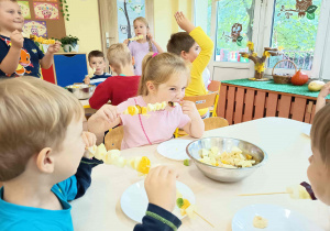 Dzieci degustują wykonane samodzielnie szaszłyki owocowe.