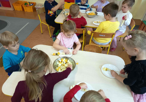 Dzieci podczas zajęć przygotowują szaszłyki owocowe.