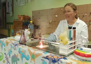 Prowadząca warsztaty pokazuje eksperyment.