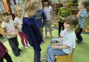 Solenizantka częstuje dzieci cukierkami.