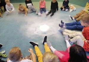 Dzieci oglądają wydobywający się ze słoika suchy lód.