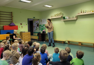 Dzieci słuchają gry na instrumencie.