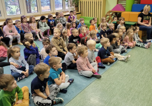 Dzieci słuchają gry na instrumencie.