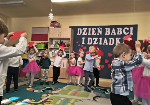 Dzieci prezentują taniec dla babci i dziadka.