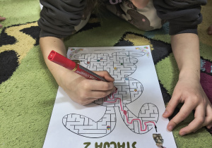 Dziewczynka rozwiązuje wielkanocny labirynt.