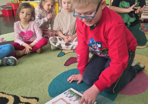 Chłopiec układa domek z patyczków.