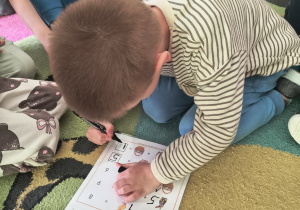 Chłopiec rozwiązuje działanie matematyczne.