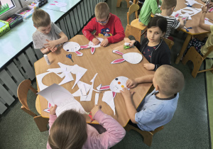 Dzieci wykonują wielkanocną pracę plastyczną.