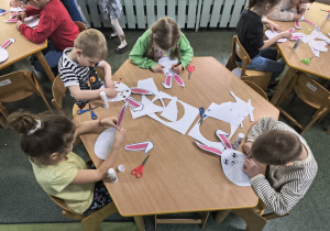 Dzieci wykonują wielkanocną pracę plastyczną.